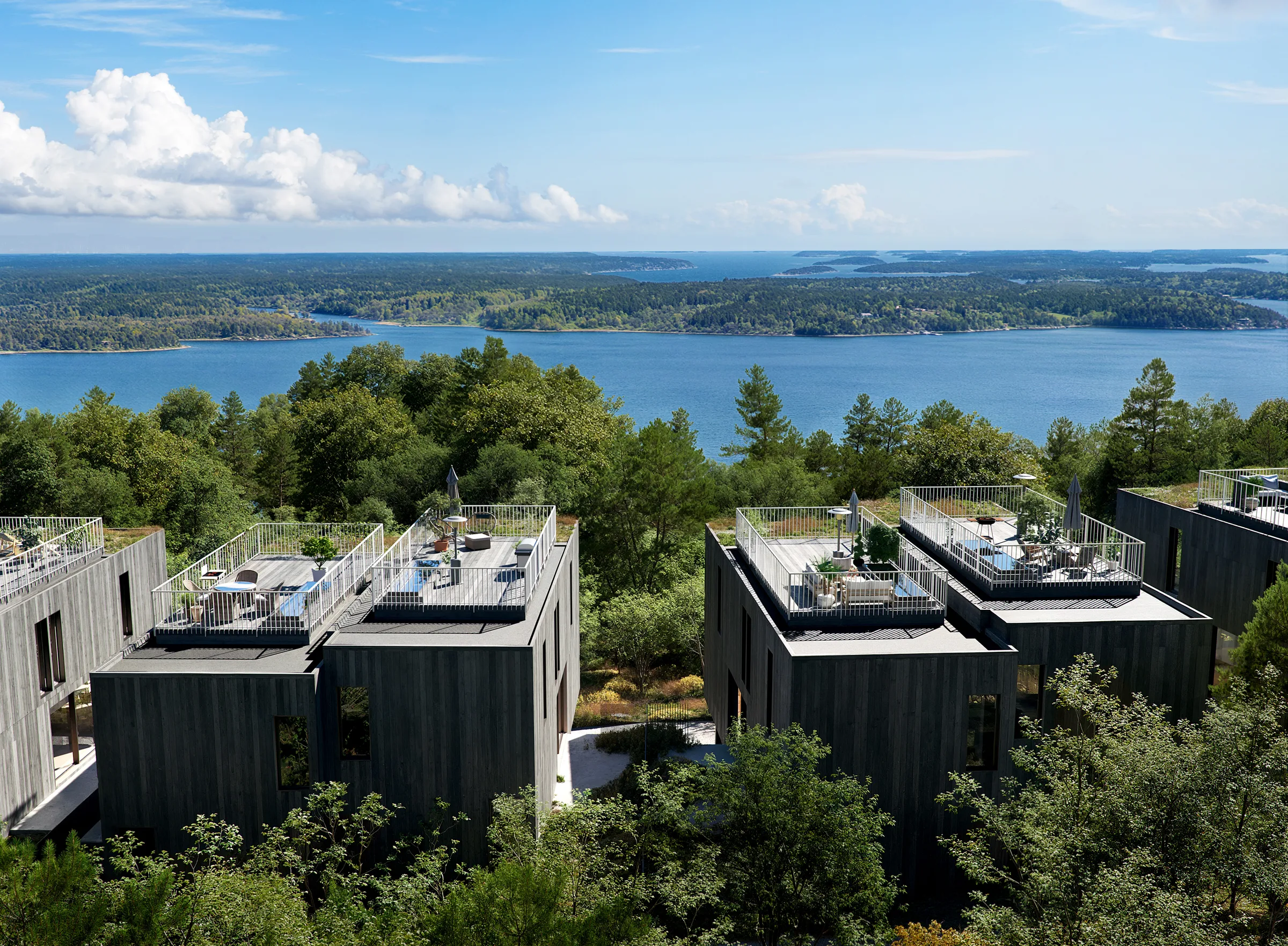 Flygvy över Tallvikens parhus med takterrasser och havsutsikt över Baggensfjärden